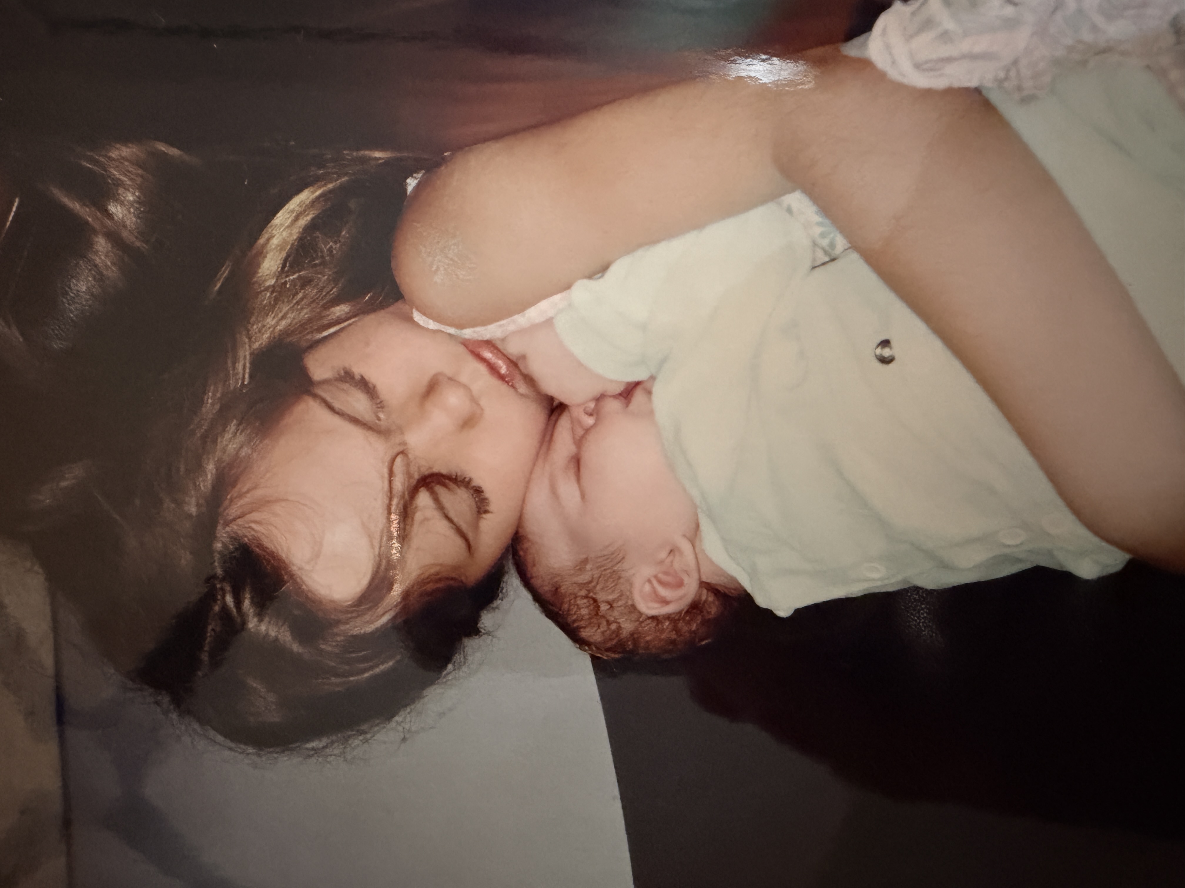 A young Kristyn, asleep with a baby on her chest.